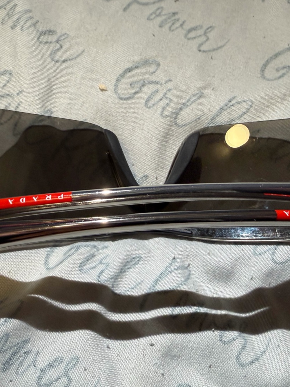 Prada Black Sunglasses with Silver Frames and Red Temple Accents